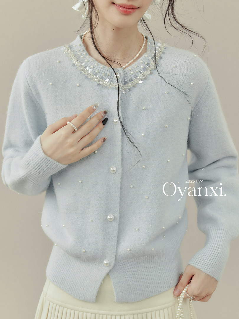 Light blue pearl-embellished knit cardigan worn by a model