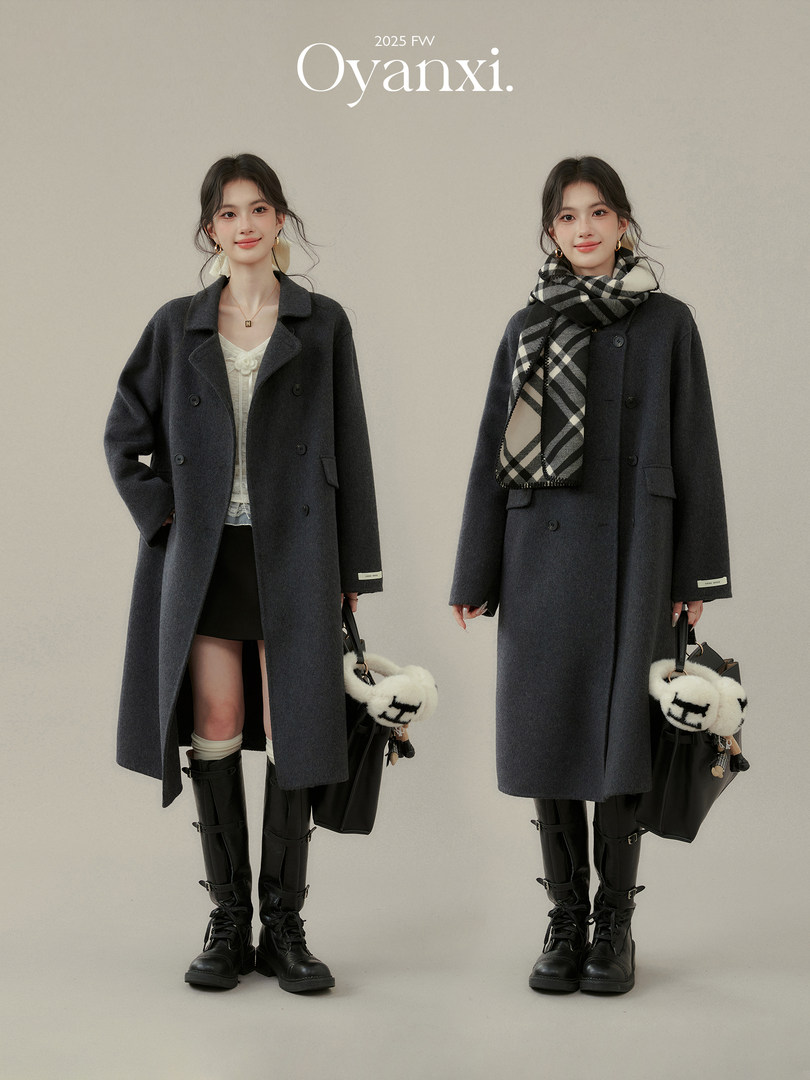 Model wearing a dark gray long wool coat styled with scarf and boots