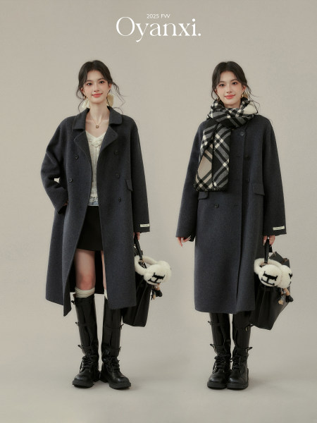 Model wearing a dark gray long wool coat styled with scarf and boots