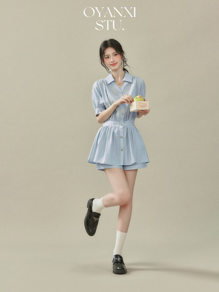 Model wearing a light blue short-sleeve belted dress with black loafers