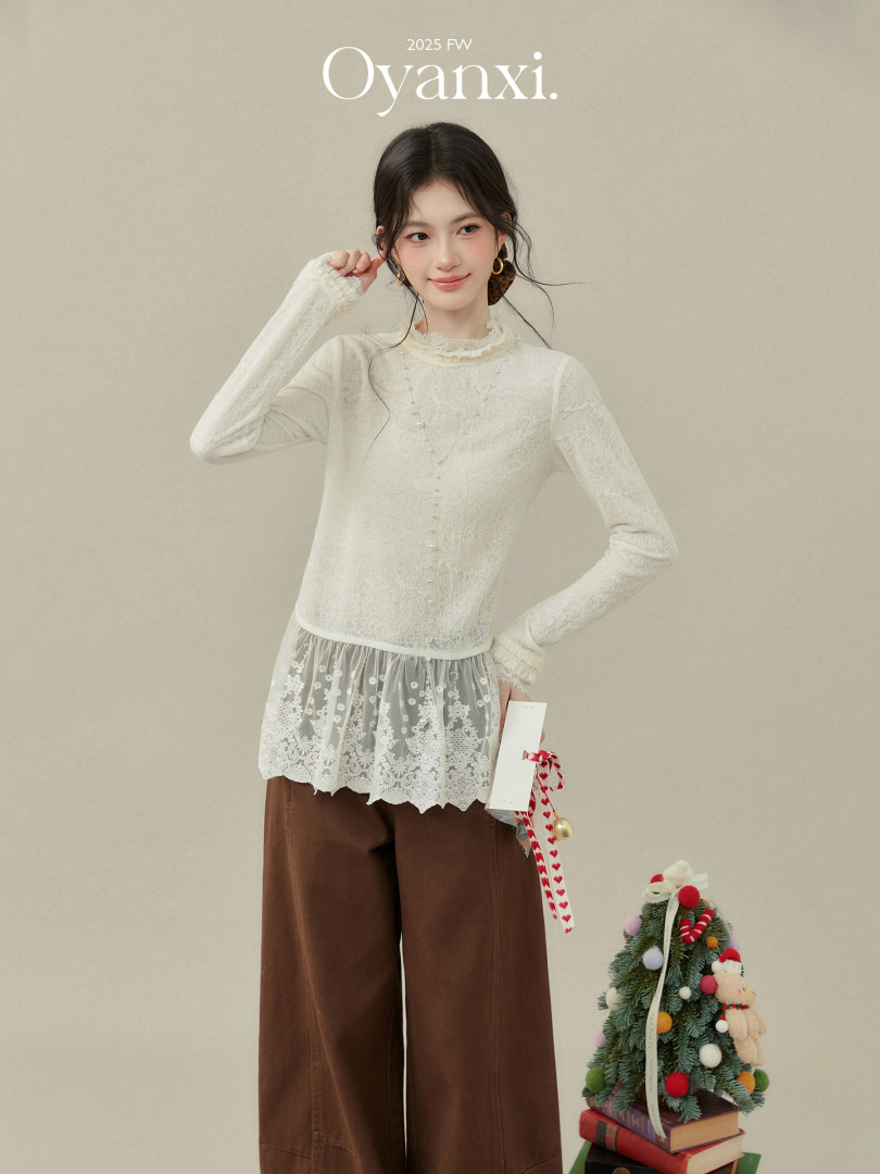 Model wearing a white lace long-sleeve top with brown wide-leg pants in a fashion editorial photo