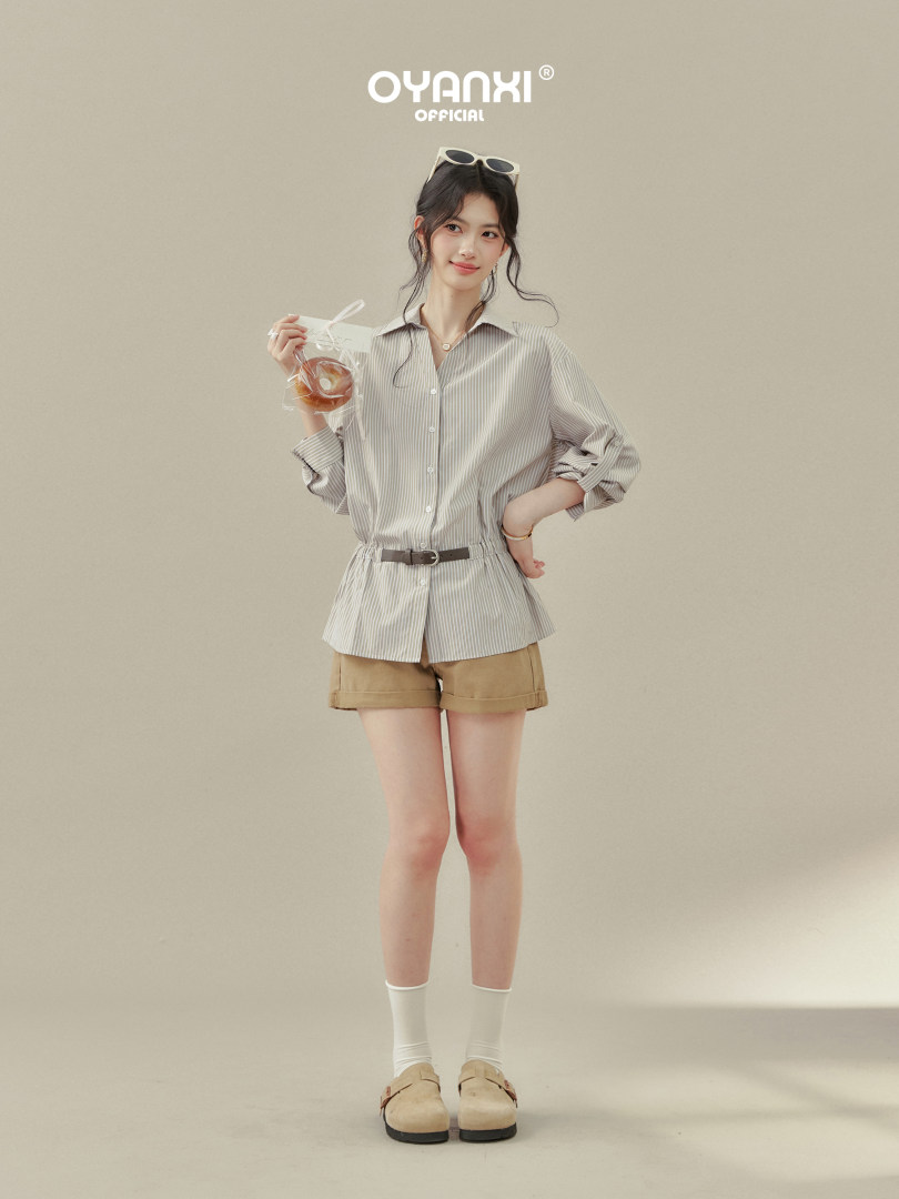 Model wearing a striped belted shirt and shorts outfit