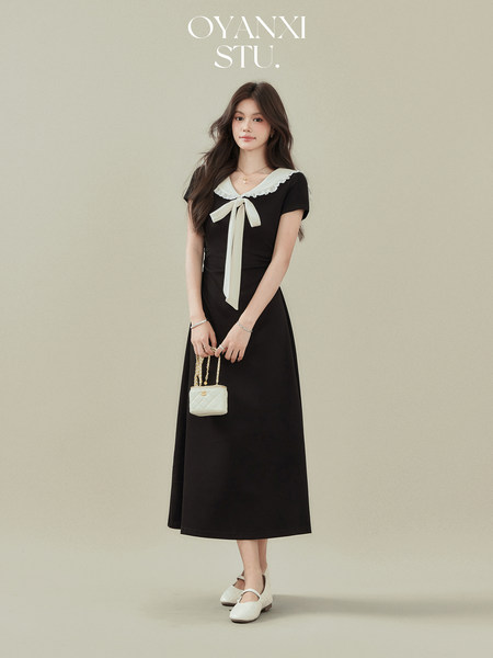 Black midi dress with white sailor-style collar and bow worn by a model
