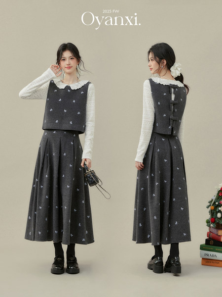 Two models wearing a dark gray bow-patterned dress set with white lace collar and long sleeves