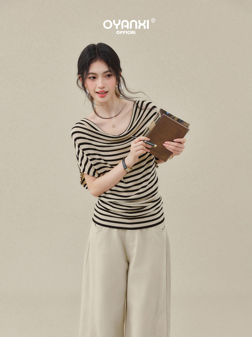 Model wearing a black-and-beige striped top with cream wide-leg pants