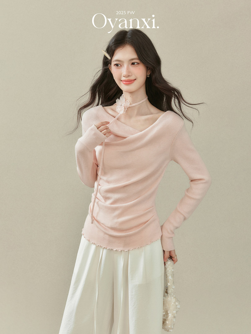 Model wearing a light pink off-shoulder long-sleeve top with a white skirt