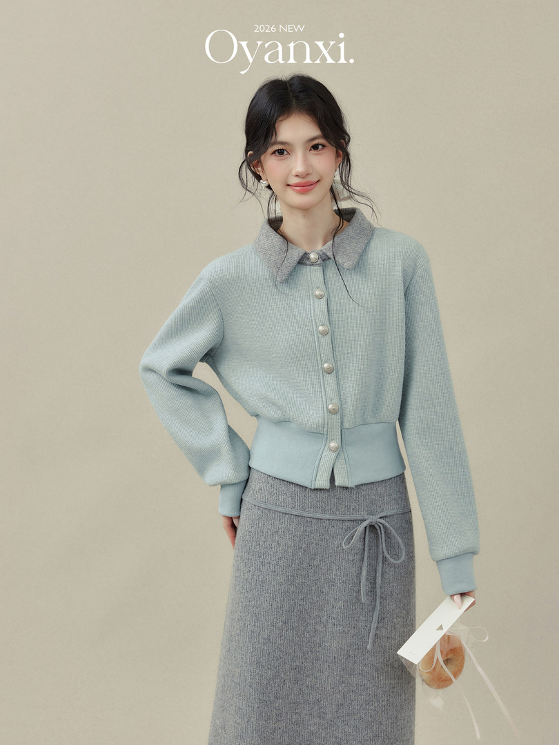 Model wearing a light blue knit cardigan and gray knit skirt set