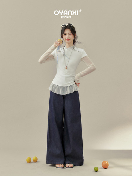 Female model wearing a white sheer layered top with wide-leg dark pants