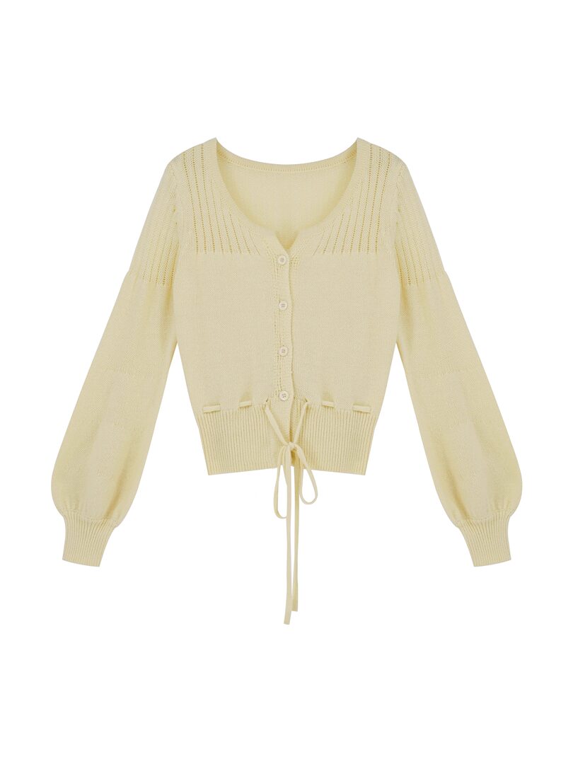 Cream knit button-front cardigan with long sleeves and tie hem on a white background