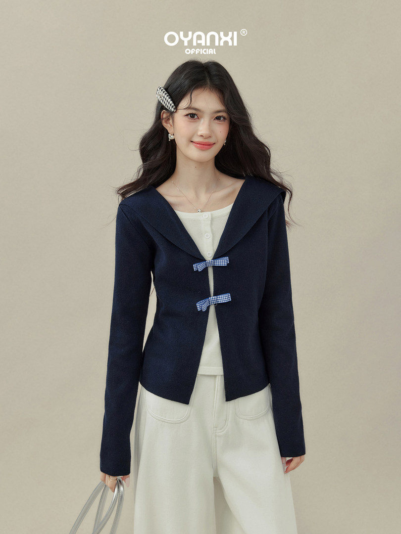 Model wearing a navy sailor-collar cardigan with white pants