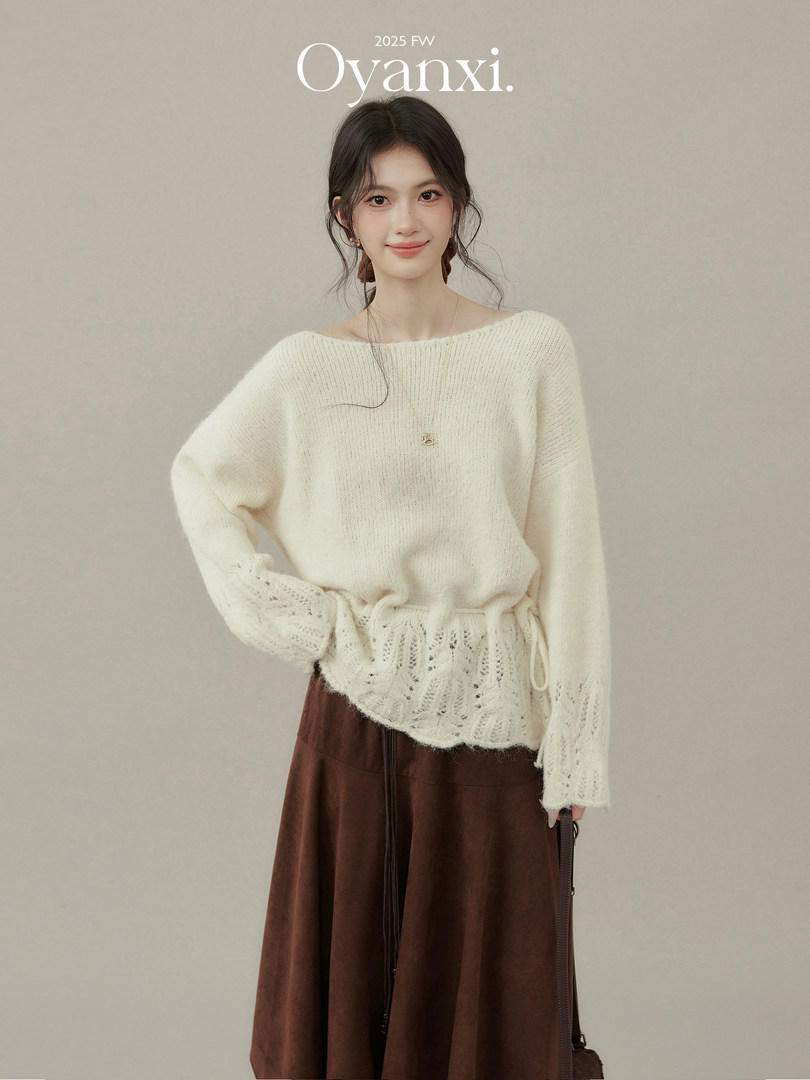 Woman modeling a cream knit sweater with a brown skirt