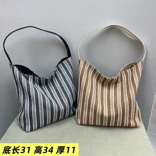 条纹水桶帆布牛皮女包2025新款洋气浅色纯色大气真皮软单肩斜挎包