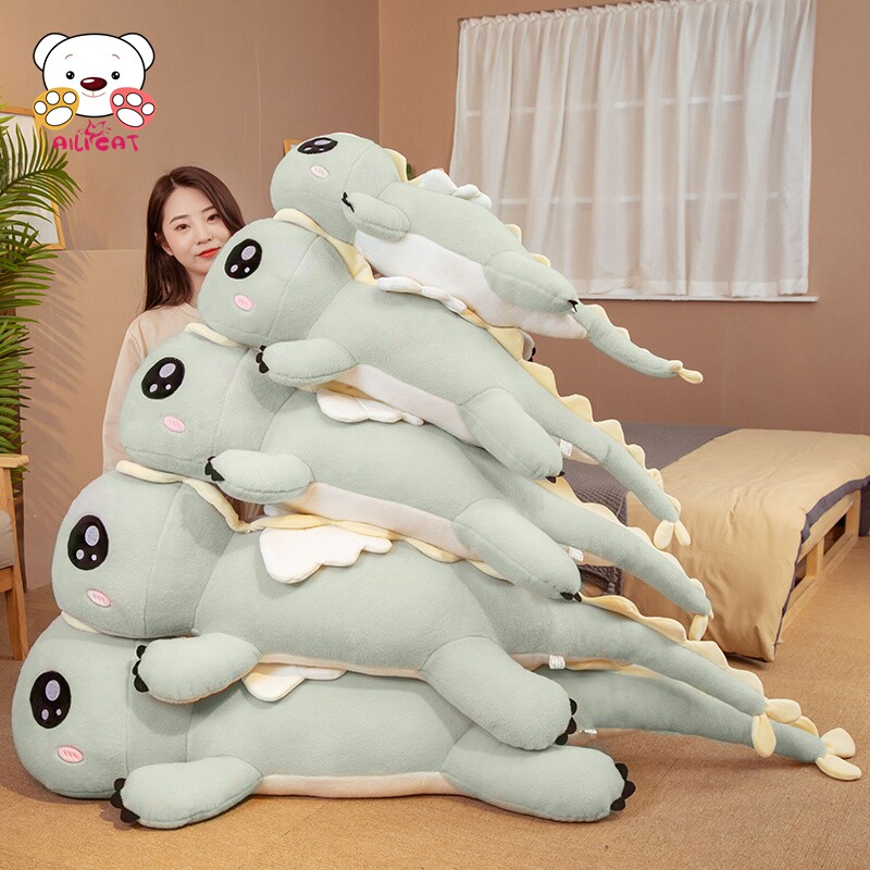 여아용 공룡 베개는 여자친구가 퀸 사이즈 침대에 붙잡고 있는 봉제 장난감 봉제 장난감 인형에서 자고 있습니다
