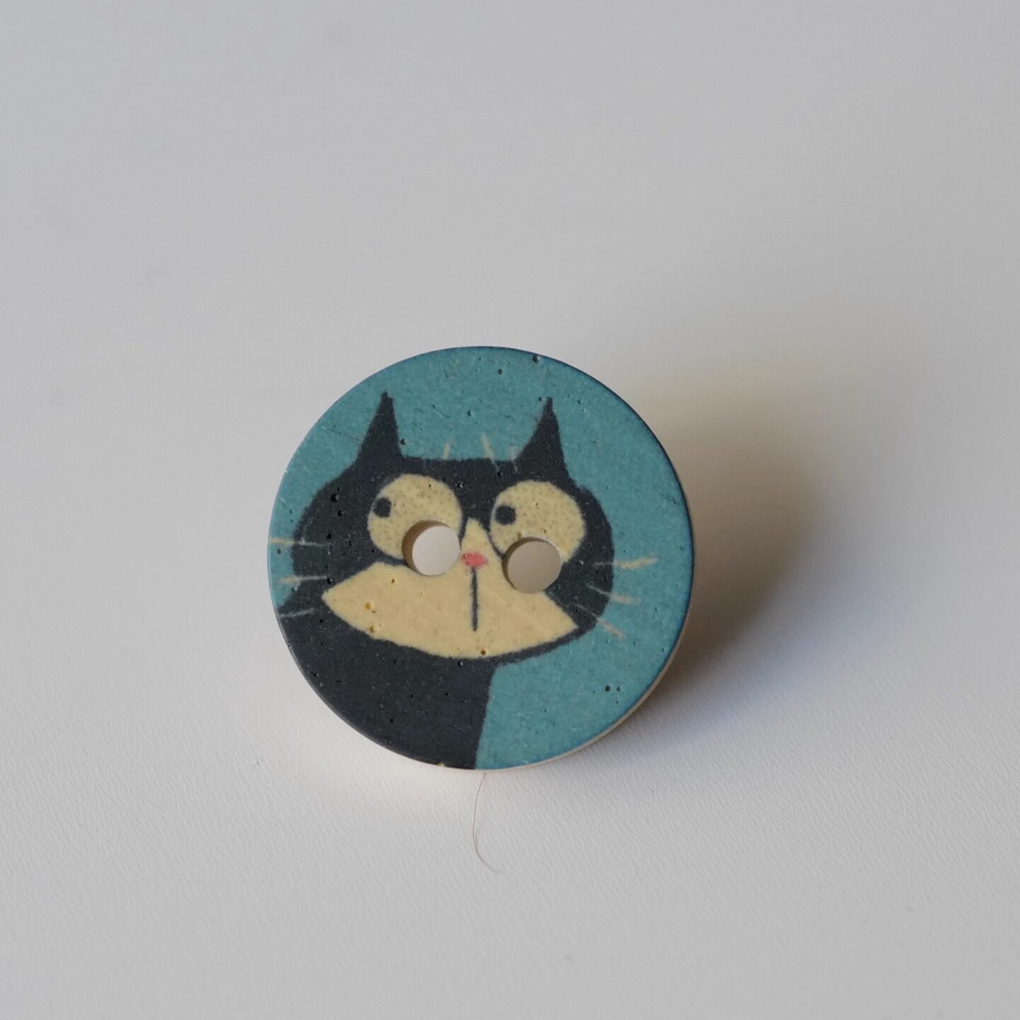 涤纶仿木蓝底好奇奶牛猫图案纽扣