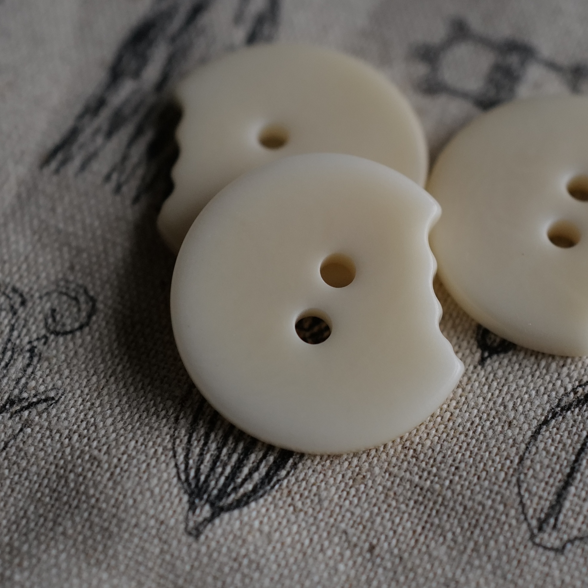 咬了一口的圆自然白未染色纽扣