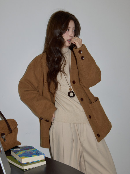 Woman wearing a brown coat over a beige outfit