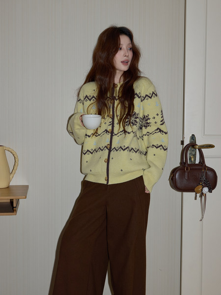Model wearing a pale yellow patterned knit cardigan with brown wide-leg pants