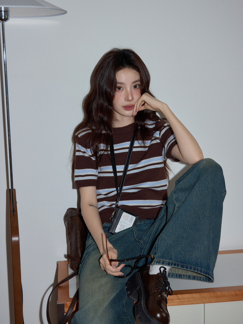 Model wearing a striped knit top with jeans and boots