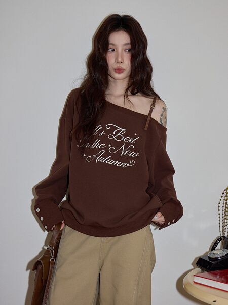 Brown off-shoulder long-sleeve top worn by a model with autumn text print