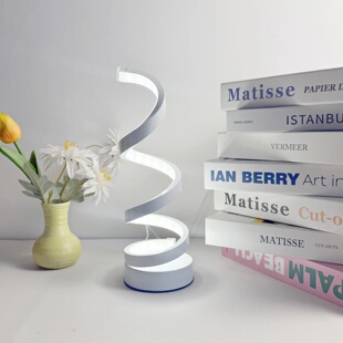 A modern, elegant white spiral desktop lamp, powered by USB