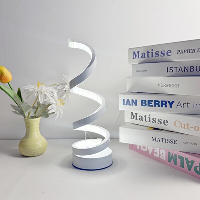 A modern, elegant white spiral desktop lamp, powered by USB