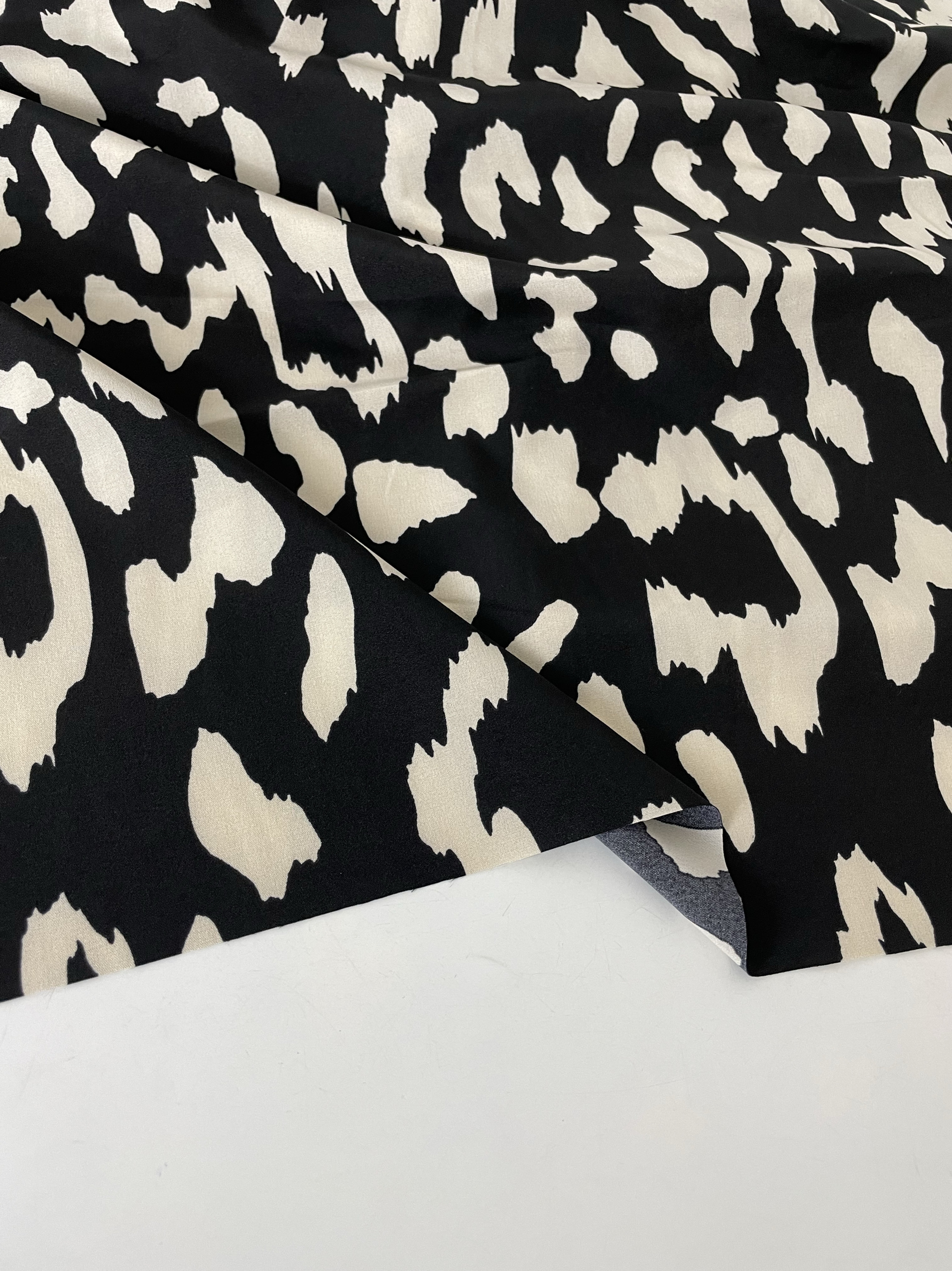 E637黑底米黄色印花聚酯纤维布头柔软垂坠透气连衣裙上衣旗袍面料