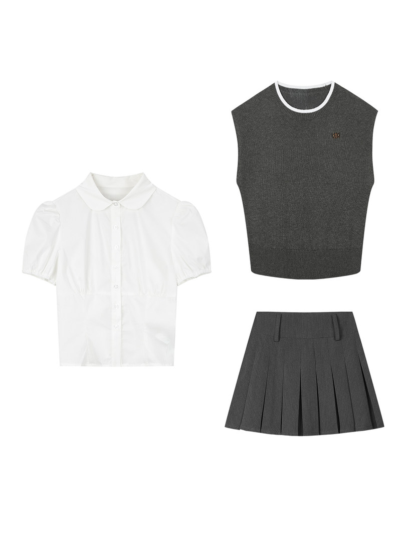 Three-piece clothing set with white blouse, dark sleeveless knit top, and pleated skirt on a white background