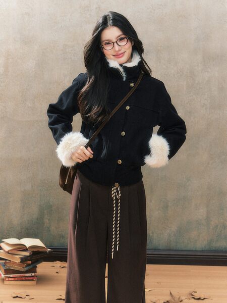 Woman wearing a black jacket with white faux fur trim and wide-leg pants