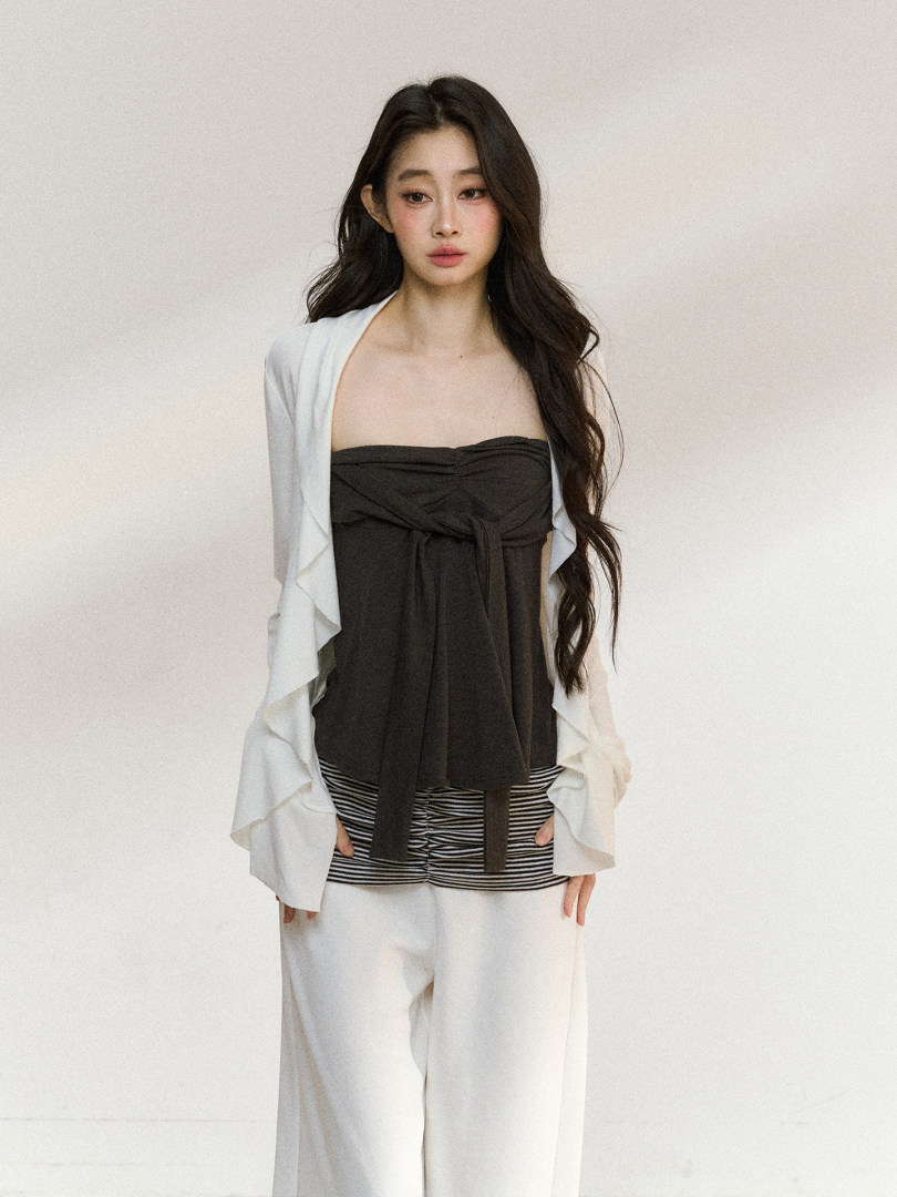 Model wearing a layered black and white fashion outfit with wide-leg pants