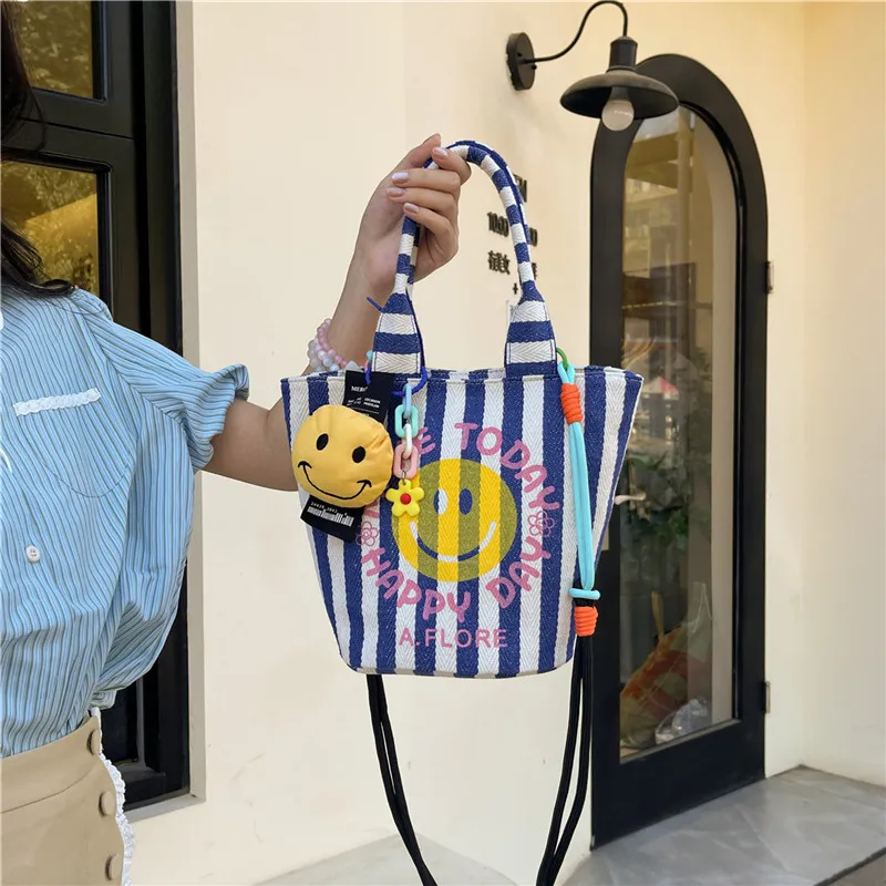 爆款韩国东大门笑脸印花水桶帆布包包2025新款撞色条纹可爱高颜值