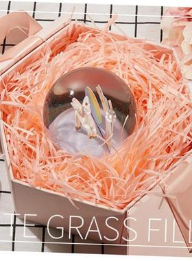 gift lined with shredded paper filling, colored packing box