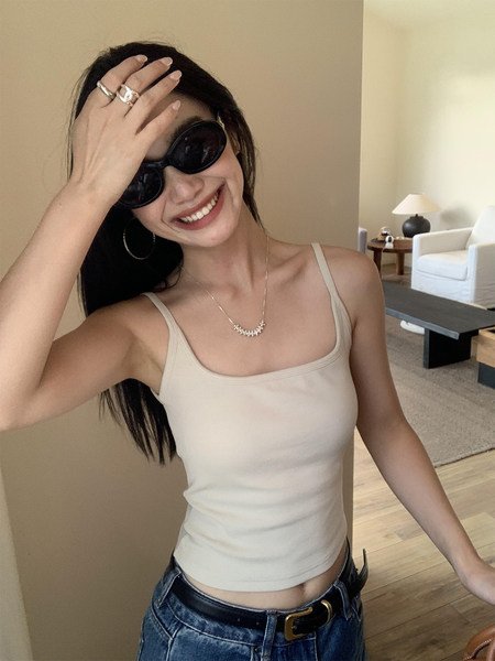 Beige ribbed tank top worn by a woman indoors