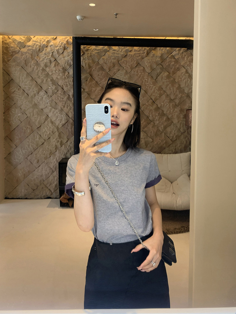 Woman wearing a gray short-sleeve T-shirt in a mirror selfie