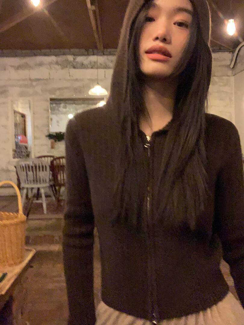 Dark brown long-sleeve zip-up top worn by a model