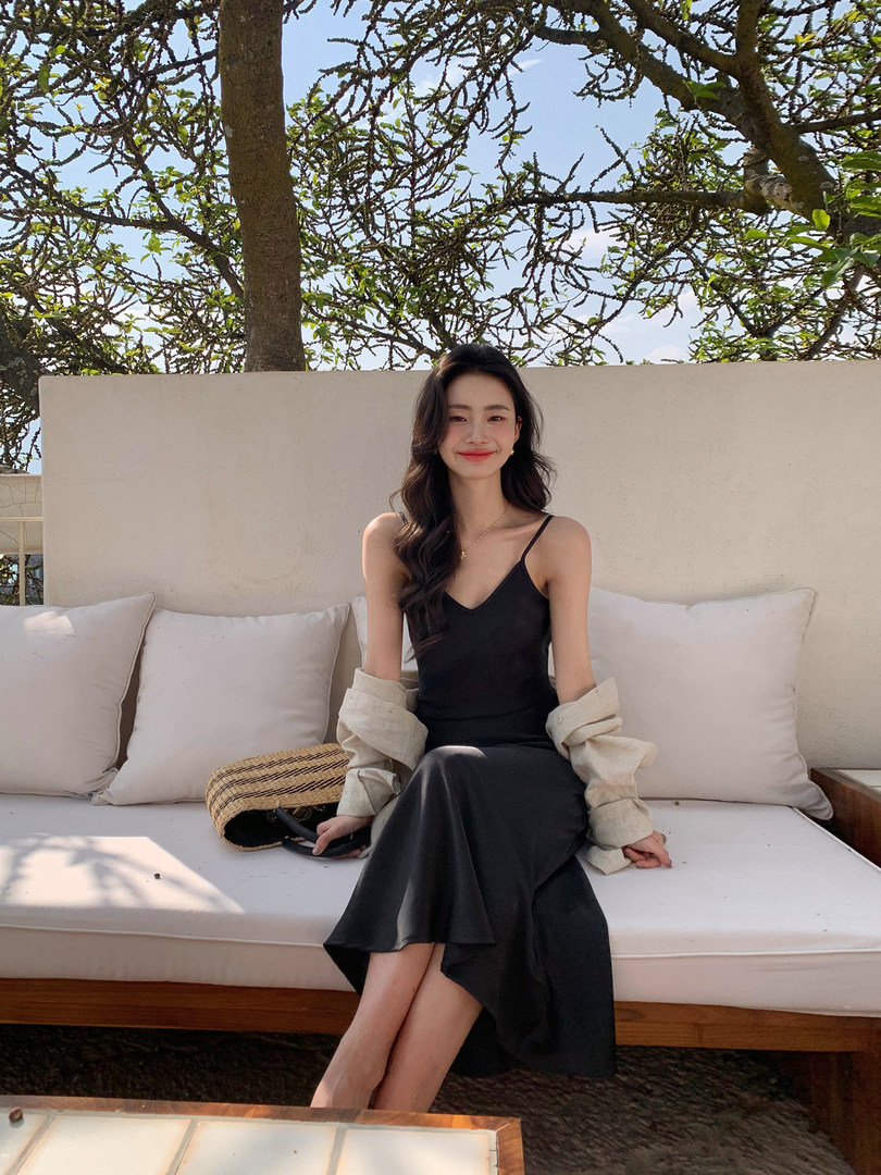 Black spaghetti-strap midi dress worn by a model outdoors