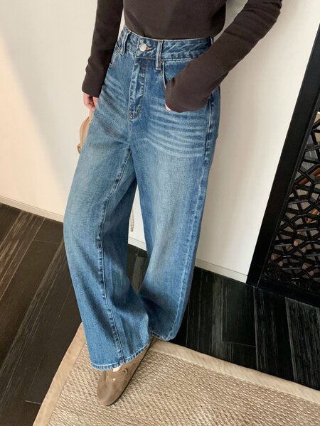 Blue high-waisted wide-leg jeans worn with a dark top and boots