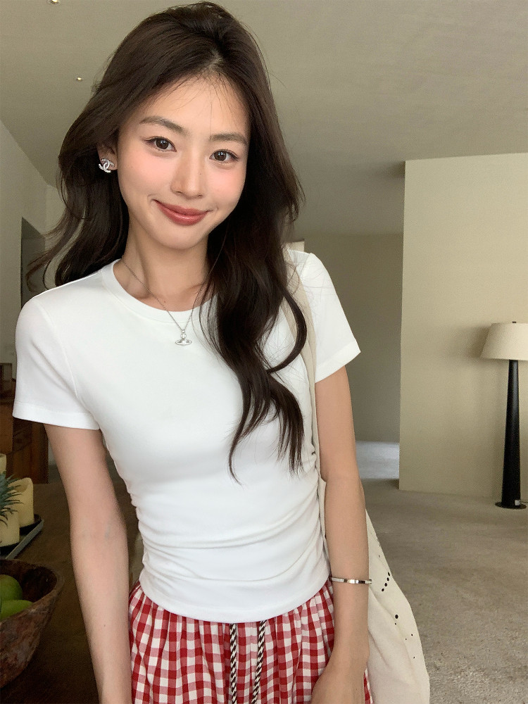 Woman wearing a fitted white short-sleeve top with a red gingham skirt