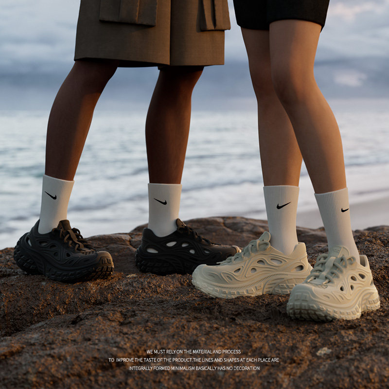 Sneakers worn with socks on a rocky beach setting