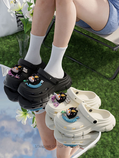 Chunky clog-style slip-on shoes worn on feet in black and beige