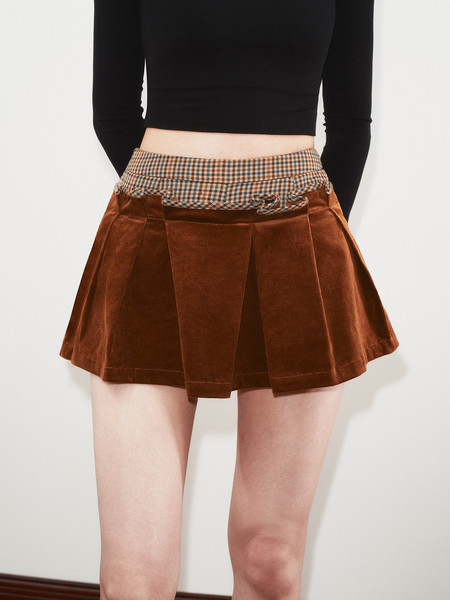 Brown corduroy mini skirt with plaid waistband worn by a model