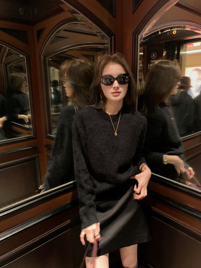 Black fuzzy sweater dress worn by a model with sunglasses