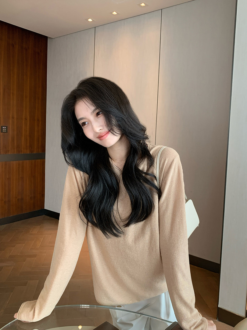 Woman wearing a beige long-sleeve knit sweater