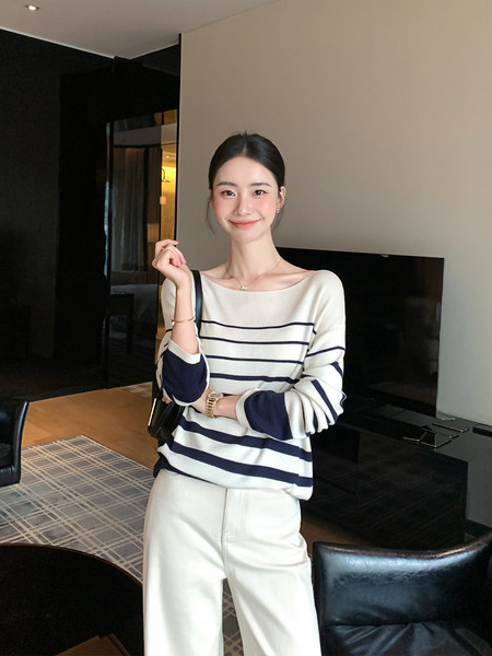 Model wearing a navy and white striped long-sleeve top with white pants