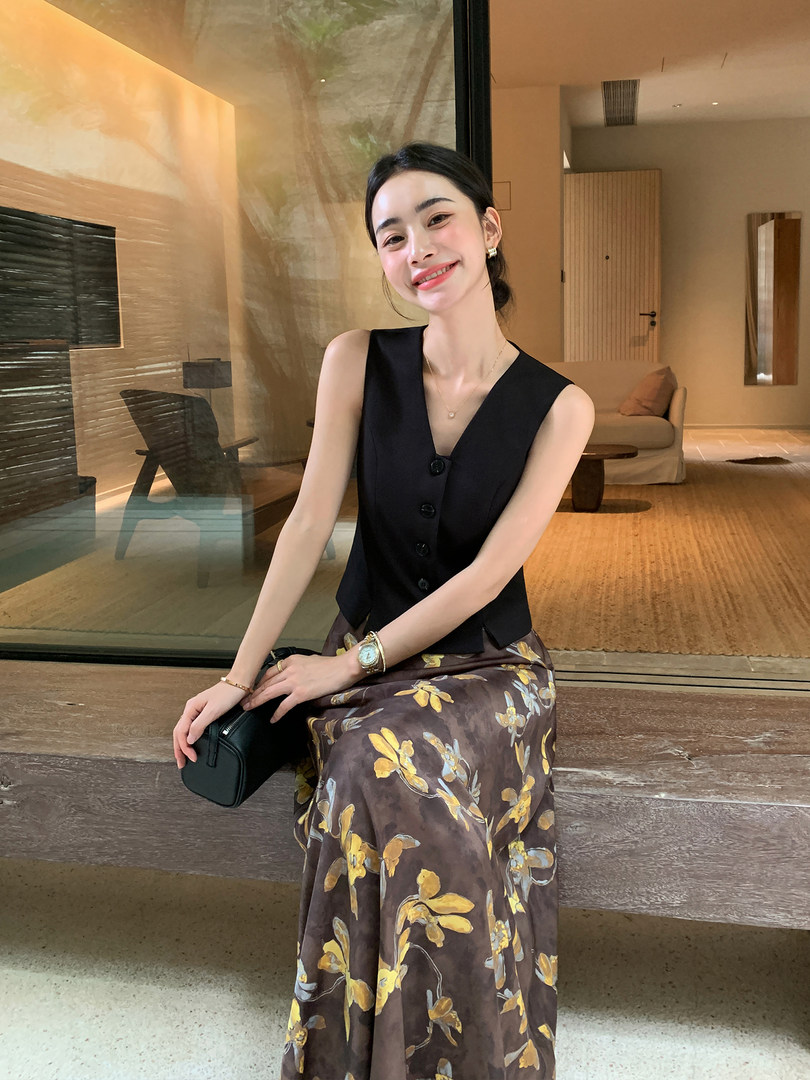 Woman wearing a black sleeveless vest with a brown floral skirt
