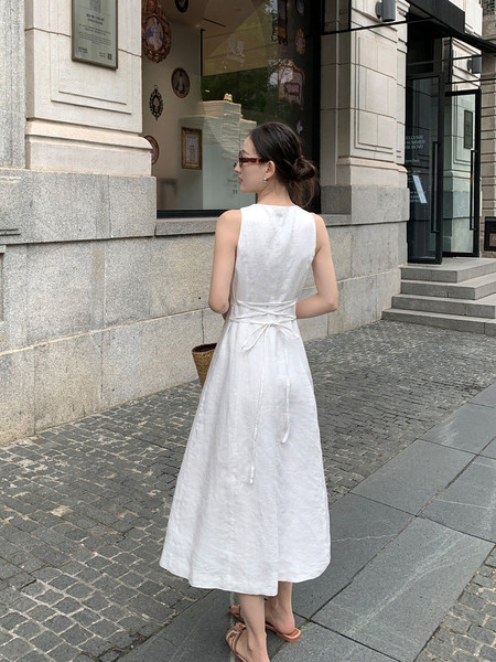 White sleeveless midi dress worn by a model outdoors