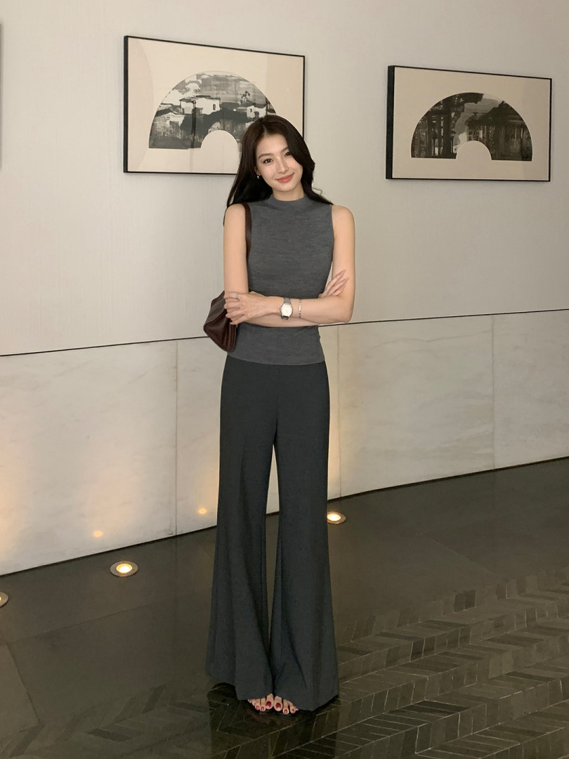 Woman wearing a sleeveless gray top with wide-leg dark pants