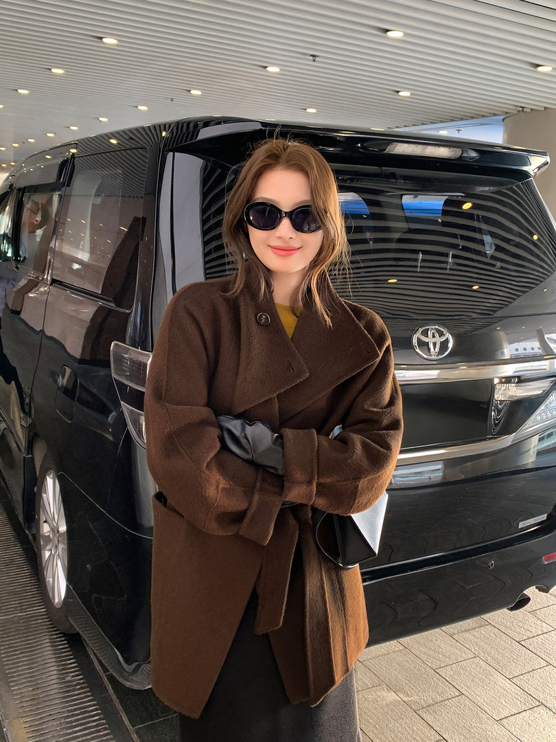 Woman wearing a brown wool coat with black sunglasses