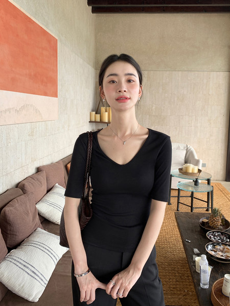 Woman wearing a black fitted short-sleeve V-neck top