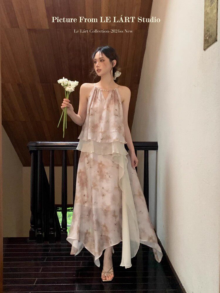 Model wearing a light floral flowy dress on an indoor staircase