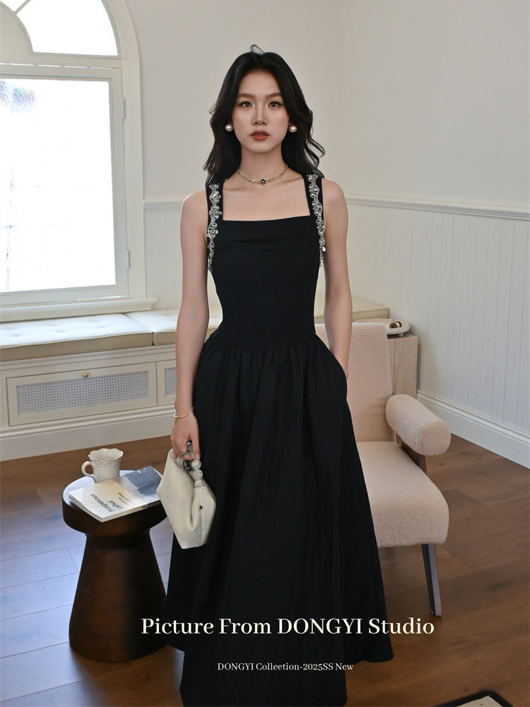 Black sleeveless square-neck dress worn by a model indoors